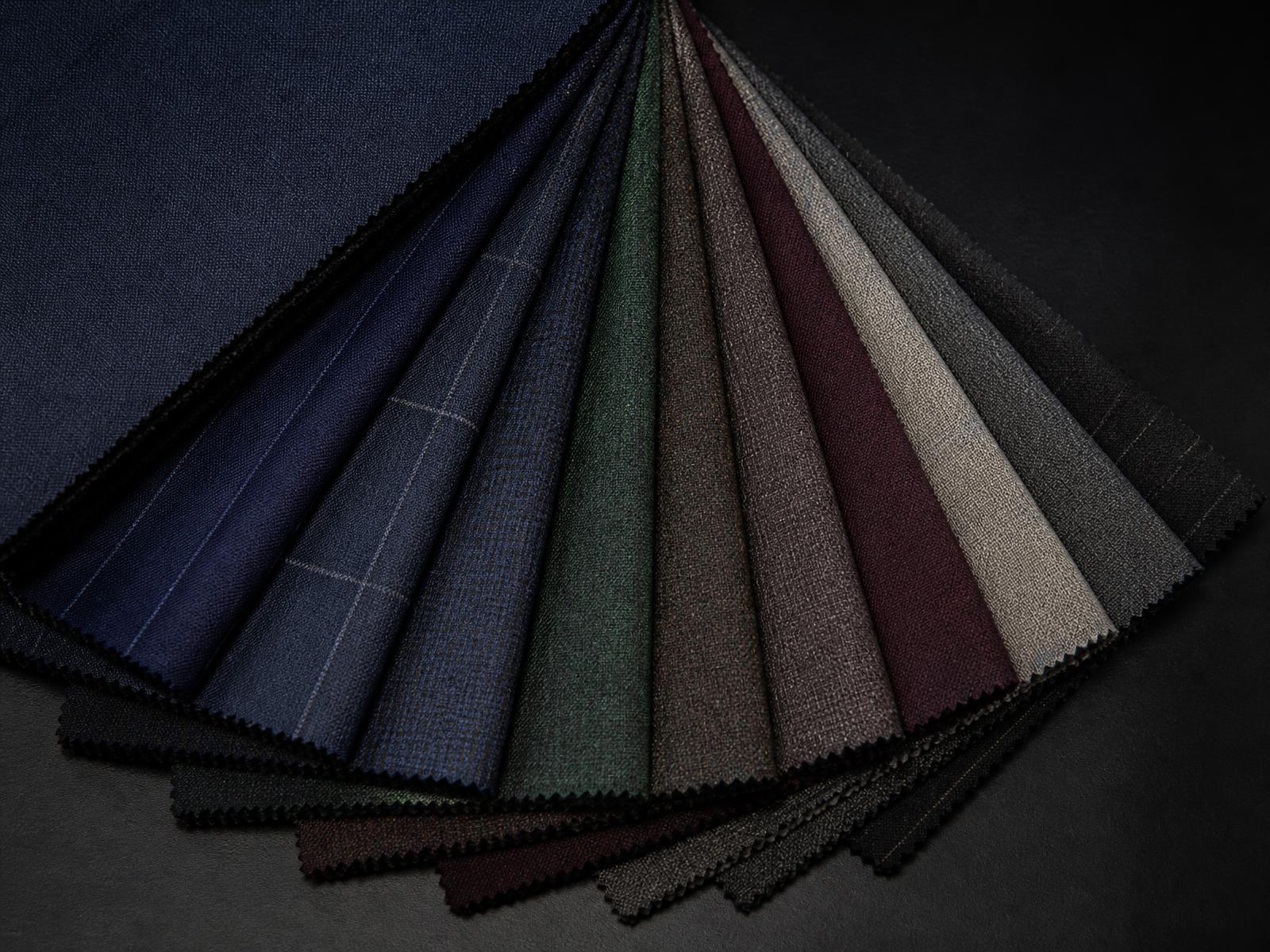 Fanned suiting fabric swatches in jewel and neutral tones
